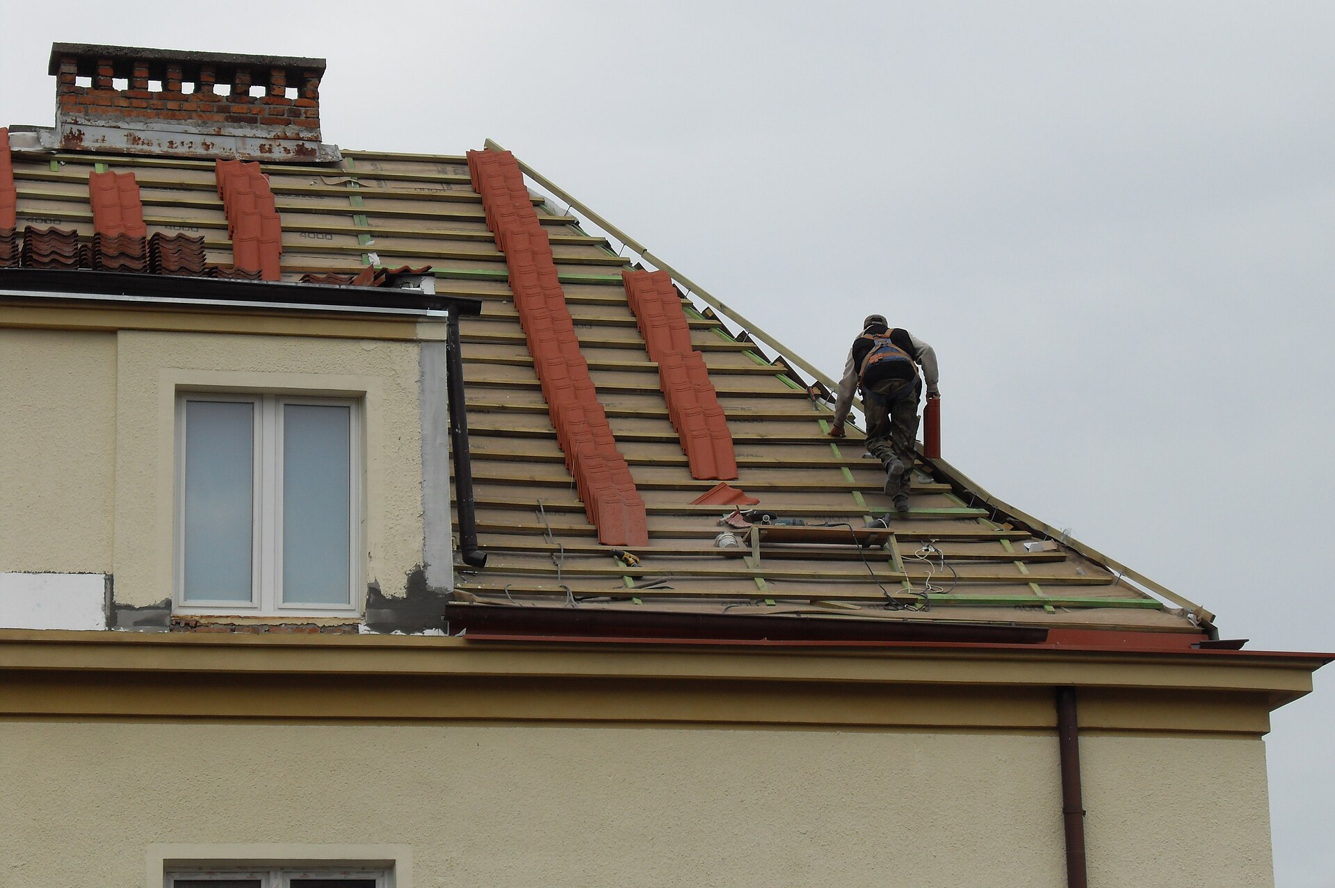 Dachdecker deckt ein Steildach mit Ziegeln ein